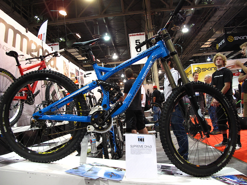 Andorran company Commencal had their latest and greatest Supreme DH on display, which is very different from the previous two versions. There are all sorts of new things going on here, including a lower center of gravity from a shock that sits low in the frame and is actually offset to one side for more drivetrain clearance. If you were to snoop around you'd also find that the blue bike uses press in BB cups, adjustable chainstay length that you tweak with removable chips, and super slick cable routing from front to back. The all important head angle sits at 64 degrees, but by spec'ing a 1.5